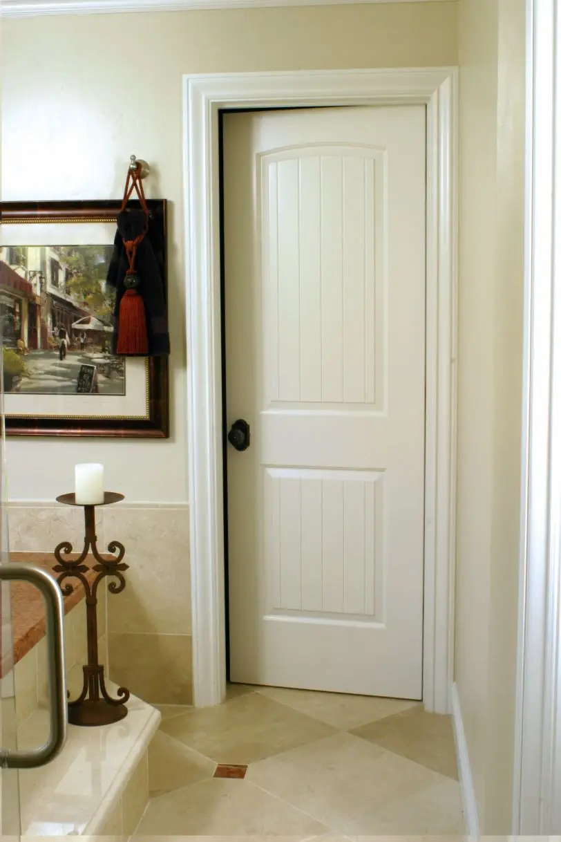 Bathroom interior with white door and painting.