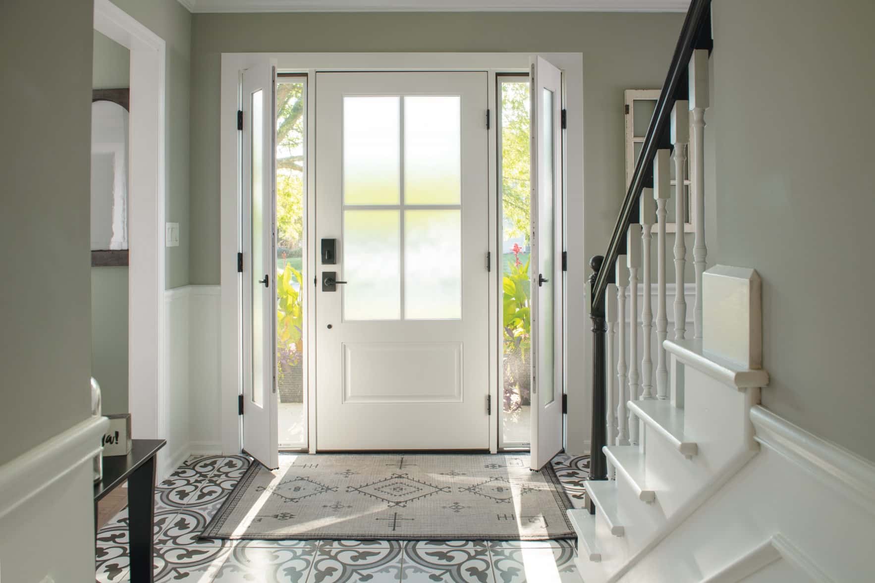 Bright entryway with patterned floor and staircase.