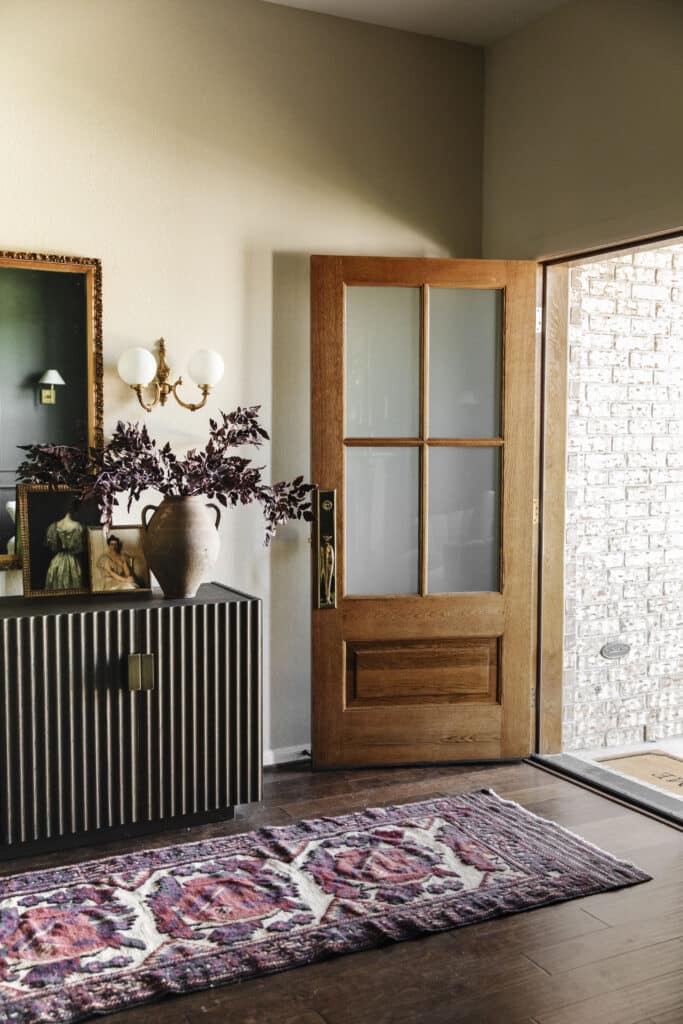 Entryway with open door and decorative items.